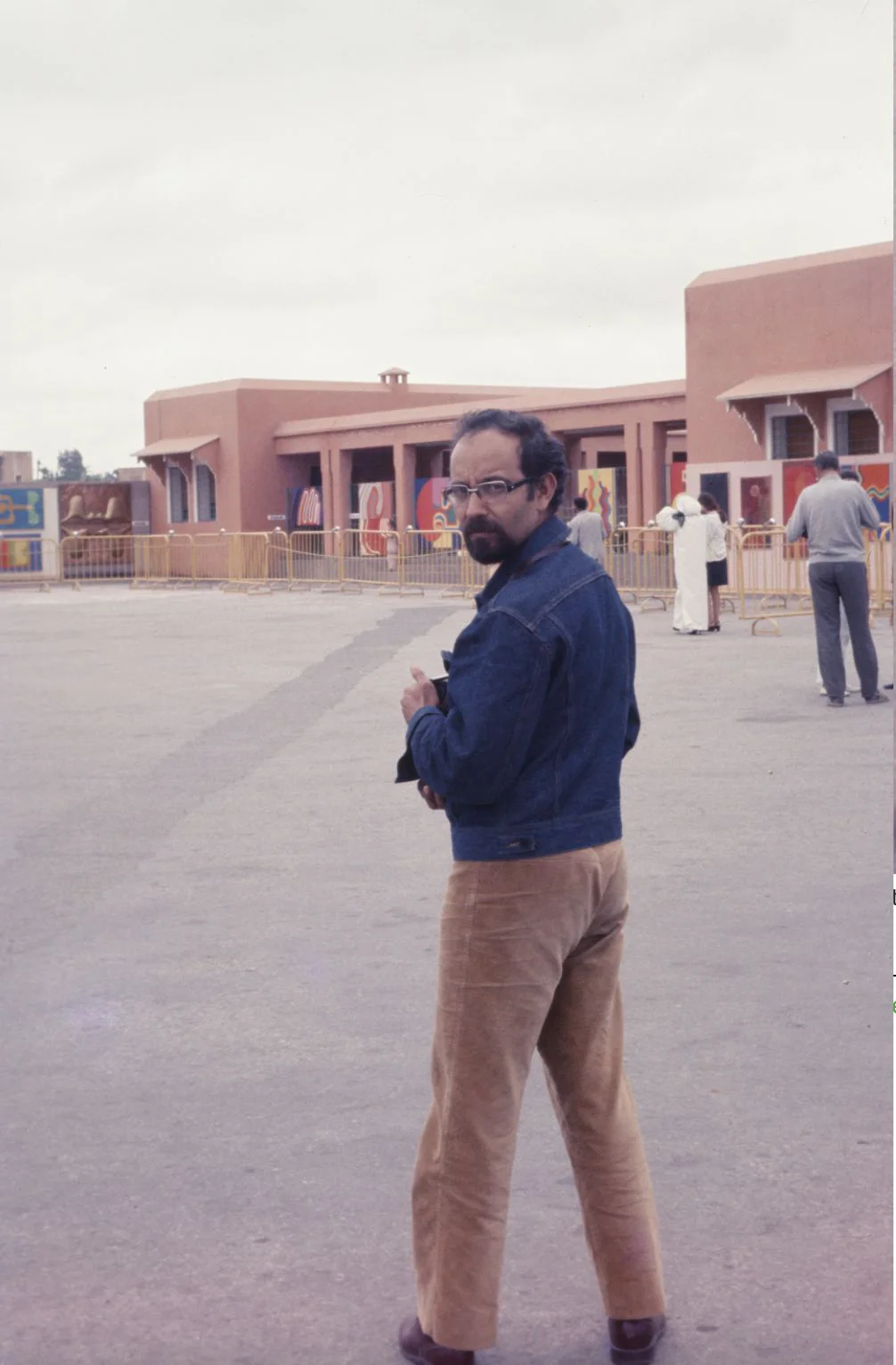 Standing in an open square before low red buildings